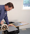 installing a waterproof vapor barrier on a basement floor to prepare for basement carpeting in a Thousand Oaks home
